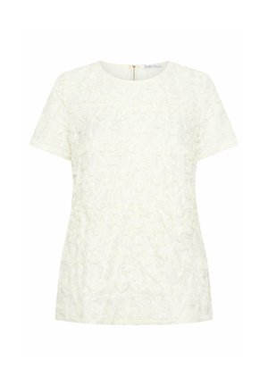 Blouse blanche à manches courtes avec motif floral texturé et encolure ronde, dotée d'une fermeture éclair au dos.