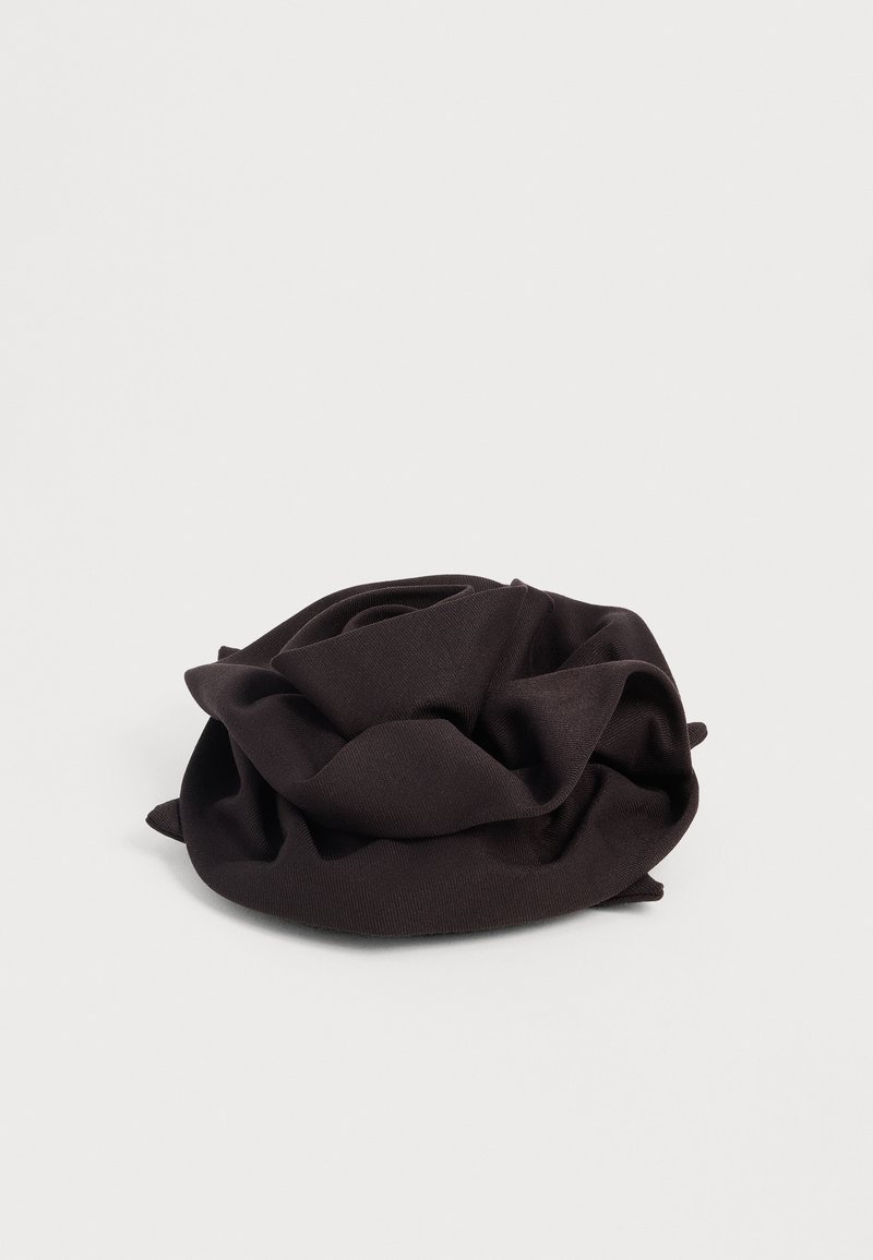 Accessoire cheveux scrunchie noir en tissu doux avec un design froncé et plissé sur fond blanc uni.
