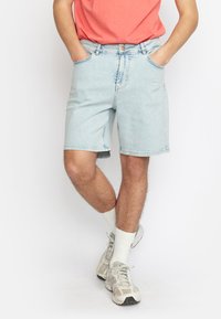 Lichtblauwe denimshorts met een rechte snit, voorzien van broekzakken aan de voorkant, een knoopsluiting en zichtbare stikseldetails.