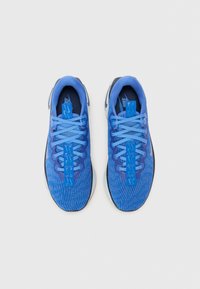 Blue athletic shoes with a textured mesh upper, contrasting dark blue accents, flat laces, and a thick black rubber sole.