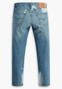 Jeans de mezclilla azul claro con corte recto, que cuentan con bolsillos traseros, áreas desgastadas y una etiqueta de cuero marrón en la cinturilla.