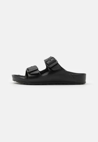 Schwarze Sandalen mit zwei Riemen aus strukturiertem Material, ausgestattet mit verstellbaren Schnallen und einem gepolsterten Fußbett mit rutschfester Sohle.
