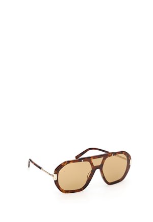 Übergroße braune Schildpatt-Sonnenbrille mit geometrischen bernsteinfarbenen Gläsern und dünnen goldenen Metallbügeln auf weißem Hintergrund.