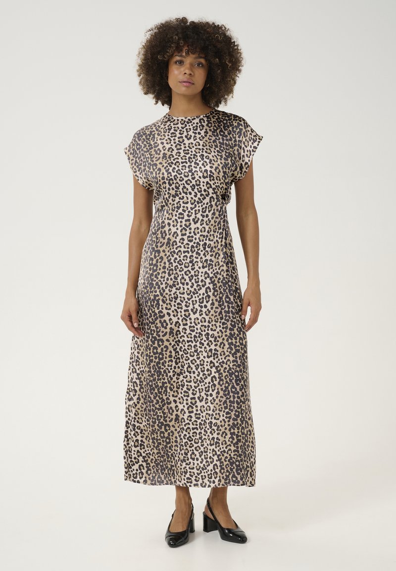 Leopardmönstrad maxiklänning med korta ärmar, mjukt tyg och en flytande design. Buren med svarta slingback-klackar.