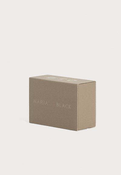Μικρό ορθογώνιο μπεζ κουτί με τις λέξεις "MARIA BLACK" ανάγλυφες στο πλάι, σε απλό ανοιχτό φόντο.