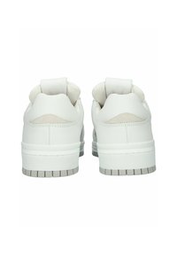 Valkoiset matalat tennarit takaa nähtynä, joissa pehmustetut kaulukset, ommellut yksityiskohdat ja teksturoidut harmaat kumipohjat.