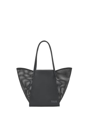 Czarna torba typu tote z gładkim środkowym panelem, perforowanymi szerokimi bocznymi panelami, długimi uchwytami i subtelnym logo „TOUS” w dolnym prawym rogu.