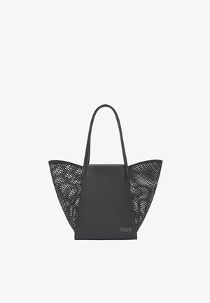 Borsa tote nera con pannello centrale solido, ampi pannelli laterali traforati, manici lunghi e logo "TOUS" discreto in basso a destra.