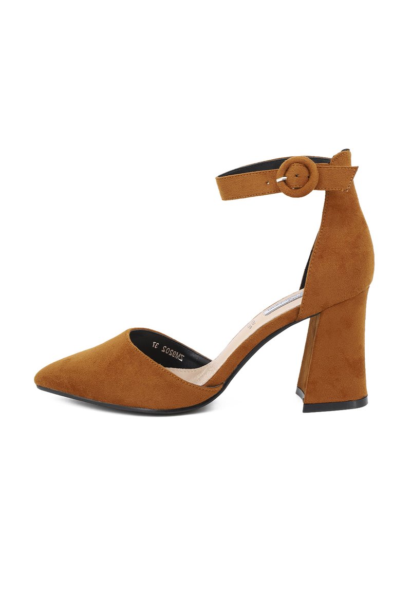 Scarpa con tacco alto in suede marrone, con punta affusolata, cinturino alla caviglia con fibbia circolare e tacco cilindrico spesso.