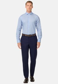 Gaiši zils svītrainais krekls ar pogām, garām piedurknēm; apvienots ar tumši ziliem biksēm un brūnu ādas jostu. Šaura piegriezuma dizains, polished apdare.