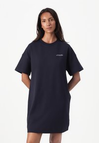 Navy übergroßes T-Shirt-Kleid aus Baumwolle mit kurzen Ärmeln, runder Ausschnitt und kleinem weißen Logo auf der Brust.