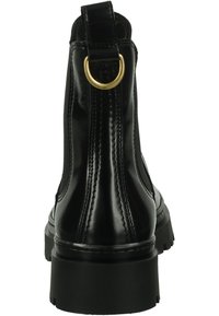 Black leather ankle boot with elastic side panels, round toe, and a thick rubber sole. Features a gold metal pull tab at the back.