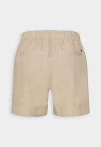 Shorts beiges avec une taille élastique, comportant deux poches arrière et des ourlets roulés. Fabriqués dans un tissu léger avec une texture lisse.