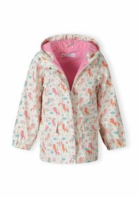 Giacca da pioggia con un motivo di unicorno e arcobaleno, sfondo crema, rivestimento in pile rosa, chiusura con zip e due tasche frontali.