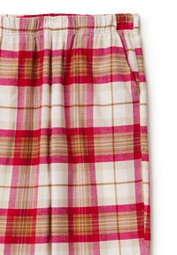 Bavlněné relaxační kalhoty s červeným, béžovým a bílým kostkovaným vzorem. Mají elastický pas a postranní kapsy.