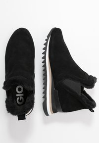 Sorte semskede ankelstøvler med faux fur-fôr, elastisk sidesømn og sagten gummisåle. Har et merke logo inni.