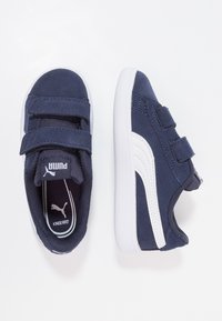 Zapatos infantiles de color azul marino con dos correas de Velcro, acentos en blanco en el costado, material de ante y tela, diseño de punta redondeada, plantilla acolchada.