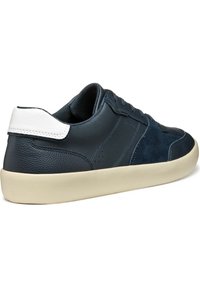 Baskets en cuir et suède bleu marine avec un contrefort blanc, présentent un design à lacets, des accents perforés et une semelle en caoutchouc beige.