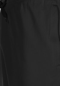 Shorts de sport noirs en tissu léger, dotés d'une taille élastique avec cordon de serrage, et de poches latérales pour plus de commodité.