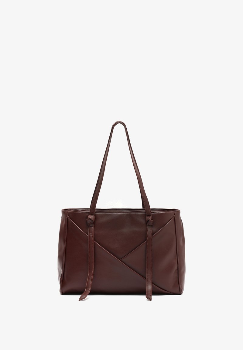 Brown leather tote bag with a geometric design, featuring two long handles and knotted accents; smooth texture and structured shape.