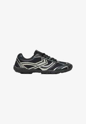 Scarpa da atletica nera con dettagli argento, tessuto a rete, design con lacci e suola texturizzata, mostrata dal lato esterno su sfondo bianco.