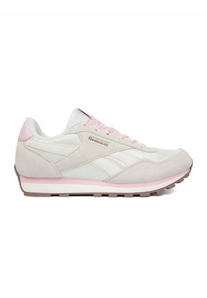 Zapatilla Reebok blanca y rosa claro con parte superior de ante y malla, cordones rosas y suela de goma marrón vista desde un lateral.