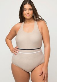 Beige éndedragt med tekstureret finish, halterneck design og kontrasterende marineblå og hvide bånd om taljen.