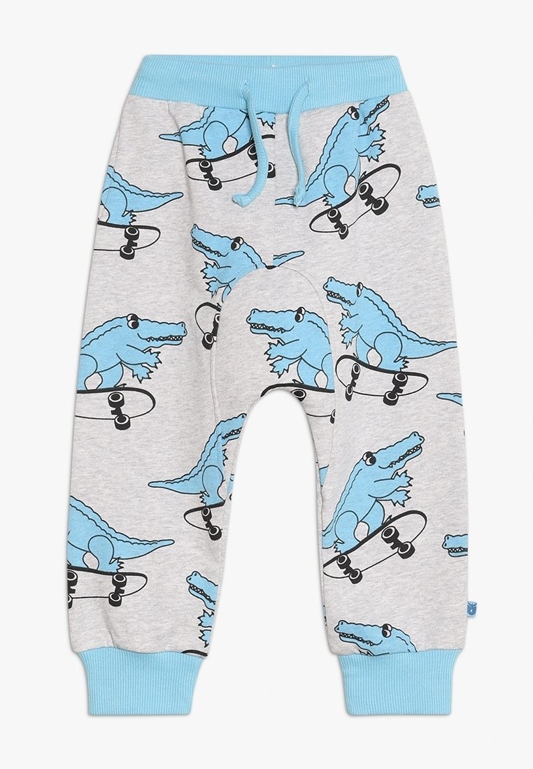 Pantaloni grigio chiaro per bambini con polsini e vita blu, con disegni di alligatori cartone animato blu che cavalcano skateboard neri su tutta la superficie.