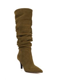 Olive green suede knee-high boot with slouchy design, pointed toe, and a thin stiletto heel. Textured surface with soft folds.