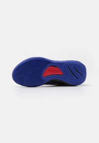 Atletische schoenzool in blauwe rubber met een getextureerd grippatroon. Kenmerkt een opvallende rode accent en zwarte gebieden nabij de randen.