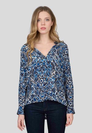 Blouse à manches longues avec un motif floral bleu, noir et blanc. Elle présente un décolleté en V et une coupe décontractée en tissu doux et léger.