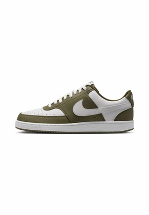 Baskets vert olive et blanches avec une tige en cuir et synthétique, bout perforé, avant à lacets et semelle en caoutchouc avec des éclaboussures blanches.