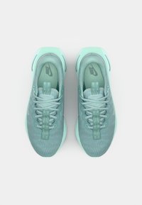 Nike tenisice u mint zelenoj boji, s teksturiranim gornjim dijelom, dizajnom na vezivanje i glatkim gumeni potplat s minimalnim oznakama branda.