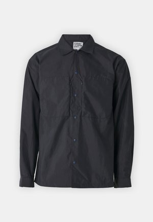 Chaqueta negra ligera con cierre de botones en la parte delantera, dos bolsillos en el pecho y botones a presión azules, con cuello y mangas largas. Adecuada para uso al aire libre.