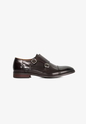 Donkerbruine leren schoenen met twee decoratieve gespen, een ronde neus en een lage houten hak. Gladde textuur met subtiele glans.