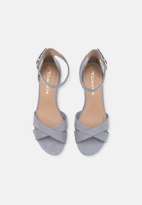 Grå mocka högklackade sandaler med korsremmar, ankelspänne och en slät beige innersula. Platt sula och öppen tå-design.