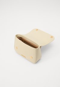Beige nahkakäsilaukku, jossa on sileä pinta, kultasävytteiset yksityiskohdat, avoin ylhäosa ja vetoketjullinen sisätasku. Tiivis ja suorakulmainen muoto.