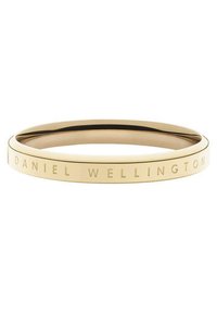 Kultaiset sävytetyt rannekorut, joissa on sileä pinta. Korun reunoilla on kaiverrettu "DANIEL WELLINGTON" -teksti. Pyöreä muoto, minimalistinen muotoilu.