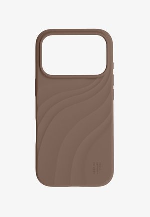Coque de téléphone en silicone marron avec des lignes texturées ondulées et une grande découpe pour la caméra en haut. Petit logo "Ideal Sweden" près du bord inférieur.