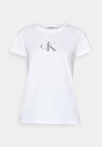 Biela bavlnená tričko s krátkymi rukávmi, s šedým logom "ck" na prednej strane. Okrúhly výstrih; voľný strih; hladká textúra.