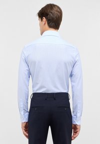Lichtblauw gestreept shirt van katoen met een klassieke kraag en knoopmanchetten, gecombineerd met donkerblauwe broek met achterzakken.