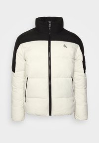 Biała i czarna kurtka puchowa z wysokim kołnierzem, przednim zamkiem błyskawicznym, zapinanymi na zamek bocznymi kieszeniami oraz małym logo "cK" na piersi.