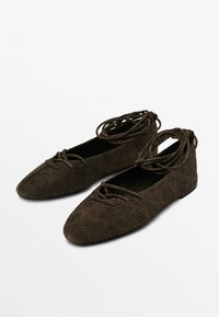 Scarpe flat marroni realizzate in materiale testurizzato con motivo in pelle di serpente. Presentano lacci incrociati e una punta a forma appuntita.