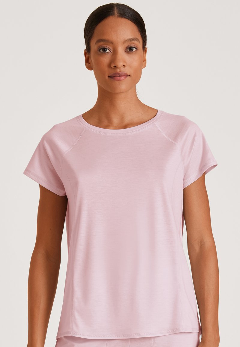 Lichtroze sportt-shirt met korte mouwen, ronde halslijn en een gladde textuur. Heeft raglanmouwen en een ontspannen pasvorm.