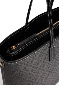 Borsa a spalla nera con esterno a trama testurizzata, hardware dorato e cuciture bianche. Include una chiusura con zip e una tasca interna.