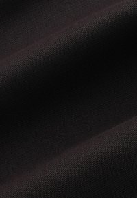 Texturiertes schwarzes Gewebe mit glatter Oberfläche, das ein dezentes Webmuster und sanfte Drapierung zeigt. Geeignet für zahlreiche Bekleidungsanwendungen.