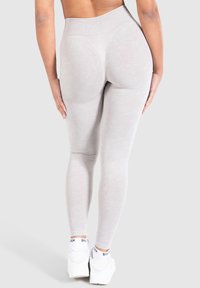 Leggings grigi chiaro a vita alta con una texture liscia e morbida. Caratterizzati da un design aderente e cuciture contornate per una forma migliorata.