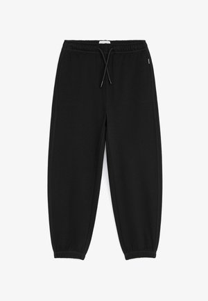 Pantalon de survêtement noir avec taille élastique, cordon, poches latérales et poignets élastiques aux chevilles.