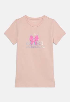 Ροζ κοντομάνικο T-shirt με ασημί κείμενο «GUESS Los Angeles Est. 1981» και φωτεινό ροζ φιόγκο στο μπροστινό μέρος.