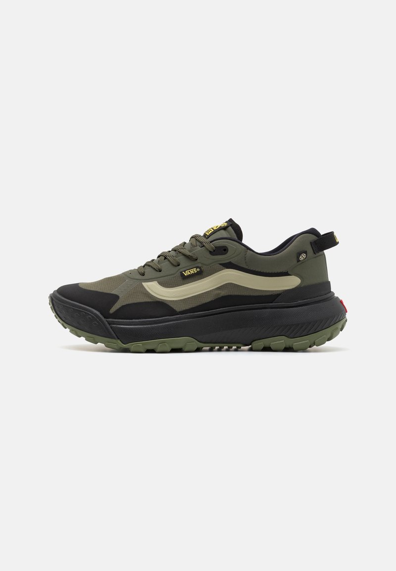 Baskets basses Vans en vert olive, noir et beige avec semelle épaisse, fermeture à lacets et détails de marque sur le côté et la languette.